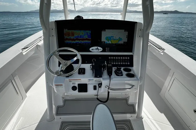  Yacht Photos Pics 2024 Southport 30 FE boat helm with advanced navigation system and steering wheel on open water.