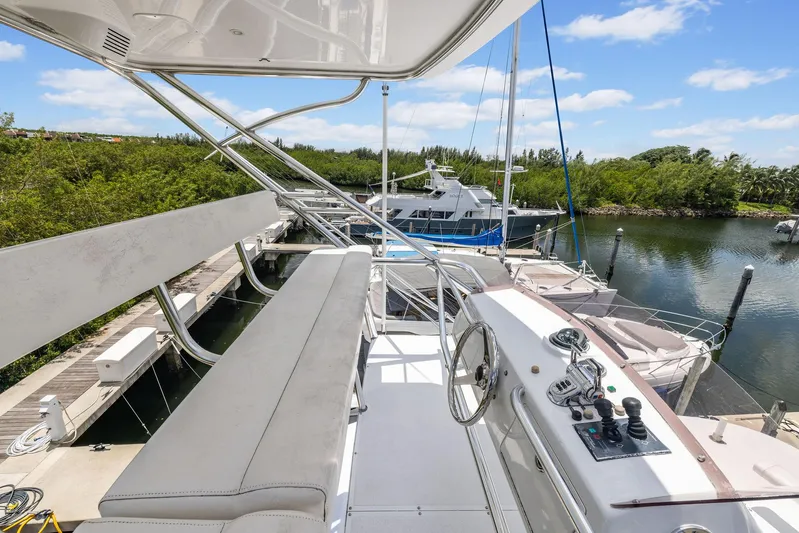 Party's Over Yacht Photos Pics 2006 Northstar Enclosed Flybridge yacht docked, featuring helm and seating area under clear blue sky.