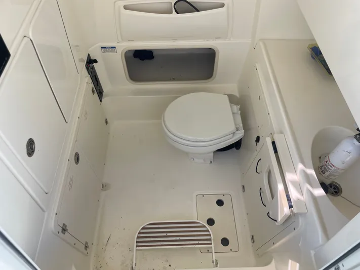  Yacht Photos Pics Interior of a 2013 Boston Whaler 320 Outrage boat, featuring a compact marine toilet.
