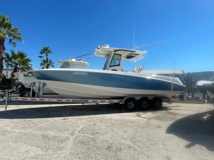  Yacht Photos Pics 2013 Boston Whaler 320 Outrage boat on trailer under clear blue sky.