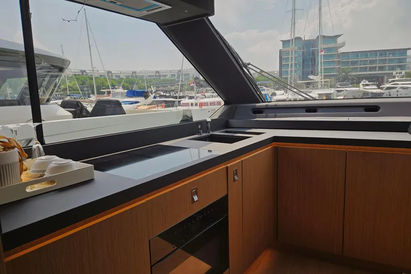  Yacht Photos Pics Modern kitchen interior on 2025 Azimut Seadeck 7 yacht, featuring sleek design and marina view.