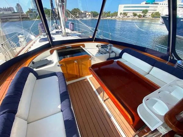 Patience Yacht Photos Pics Luxurious 1989 Irwin 54 yacht interior with elegant seating and wooden finishes, docked by the waterfront.