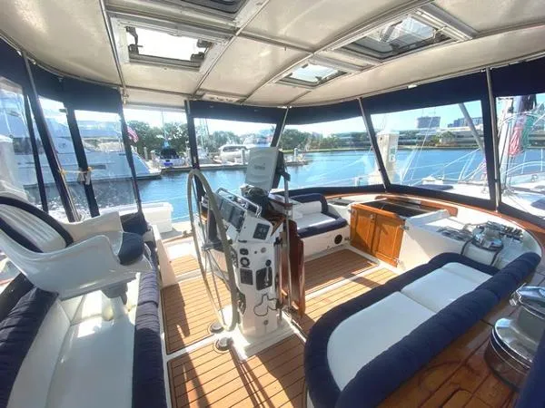 Patience Yacht Photos Pics 1989 Irwin 54 yacht interior with helm, seating, and panoramic windows overlooking marina.