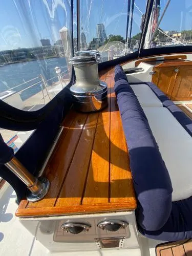 Patience Yacht Photos Pics 1989 Irwin 54 yacht interior with polished wood and blue cushions, docked in a marina.