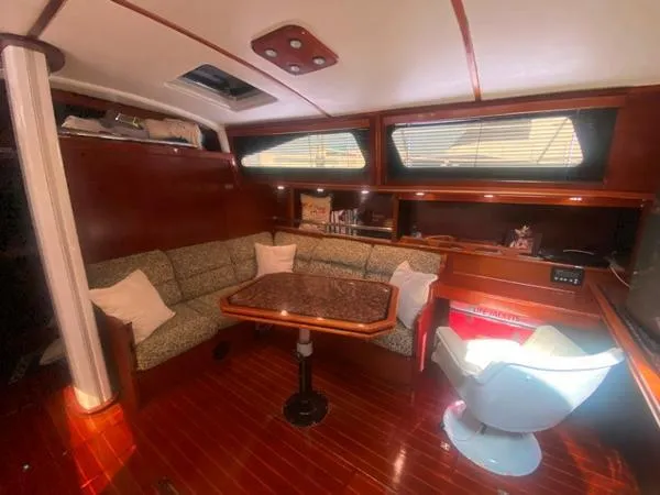 Patience Yacht Photos Pics Cozy interior of 1989 Irwin 54 yacht with seating, table, and wood finish.