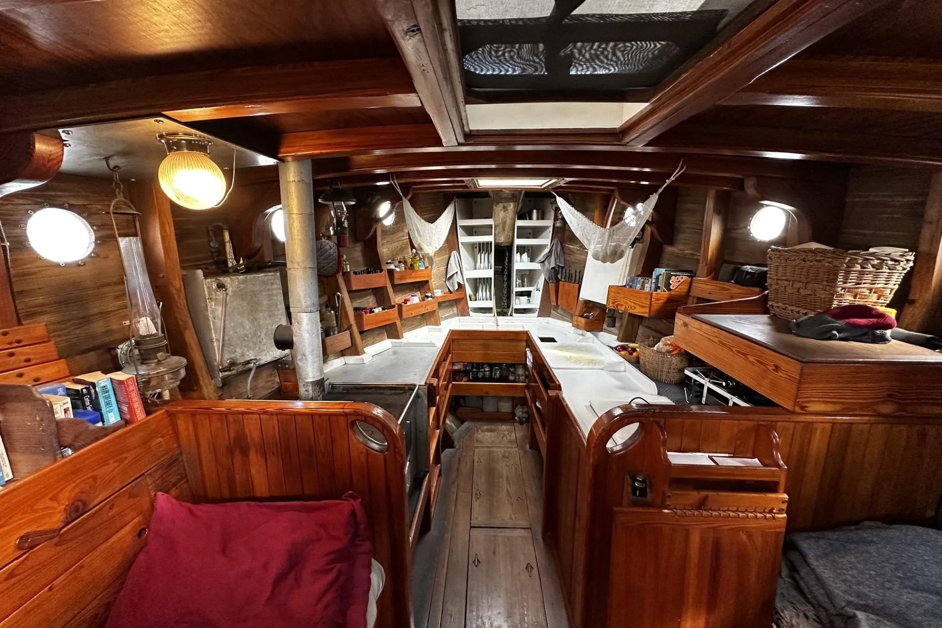 Interior of a 2005 custom sail-assisted trawler with wooden furnishings and cozy decor.