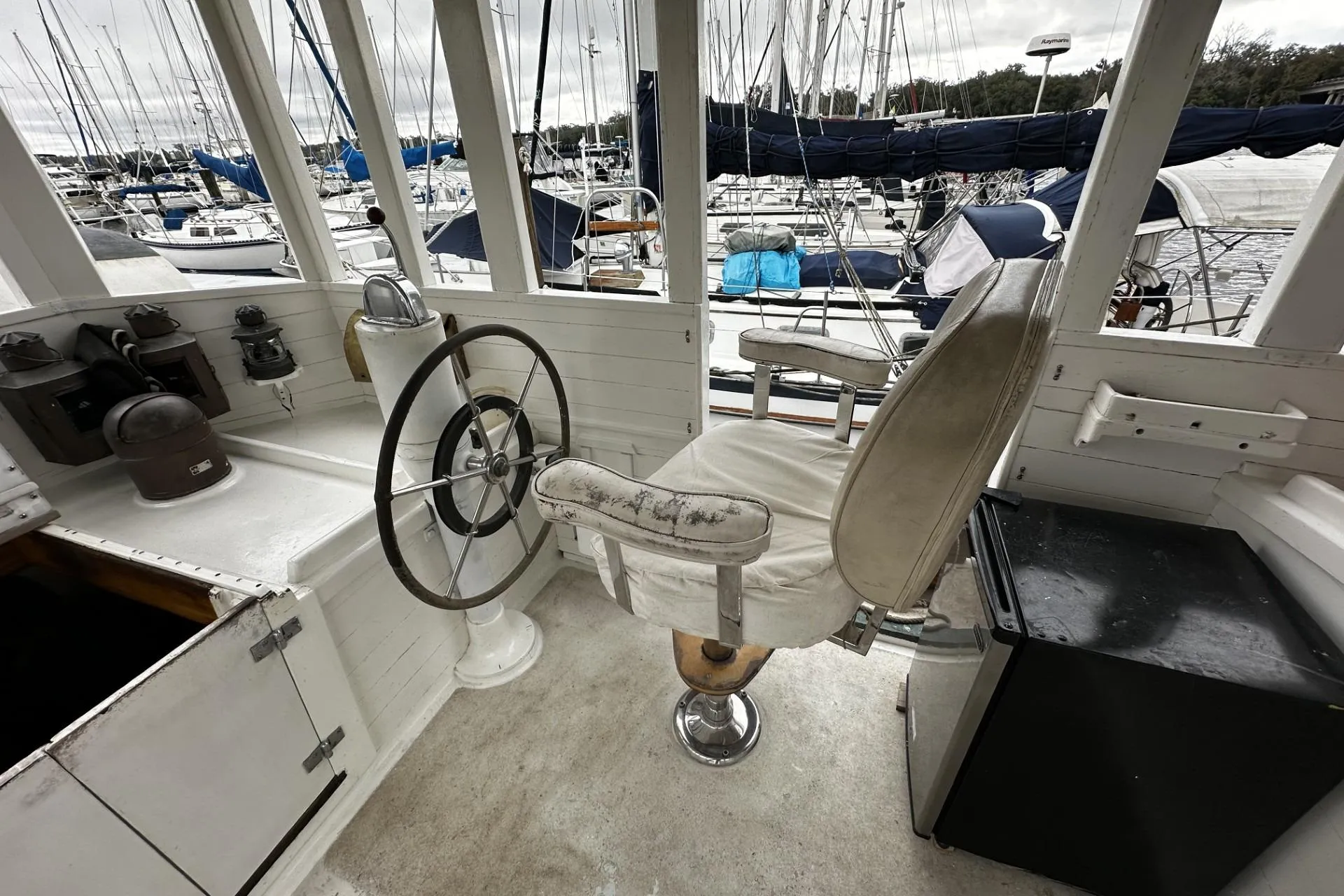 Helm of 2005 Custom Sail-Assisted Trawler with vintage steering wheel and captain's chair.