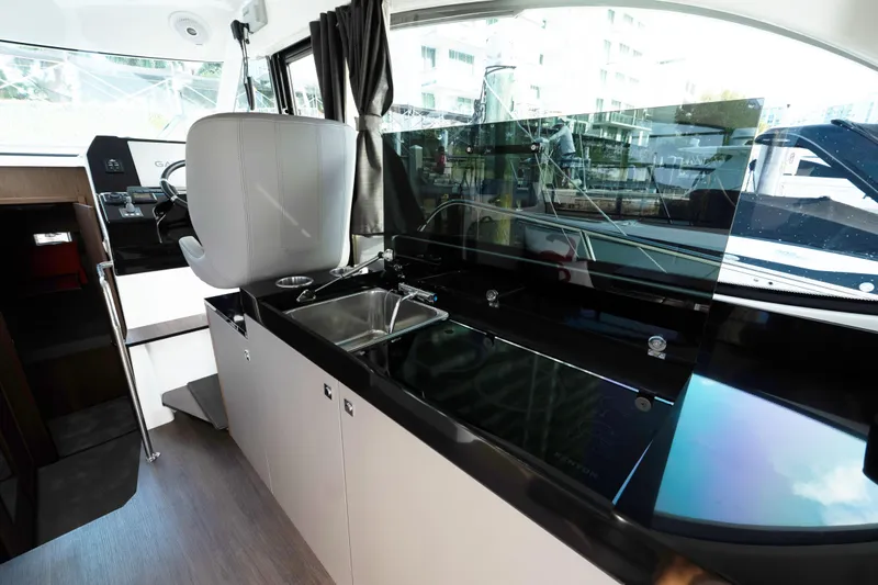 Slack Tide Yacht Photos Pics Interior of 2022 Beneteau Antares 11 Coupe, featuring sleek kitchen and helm station.