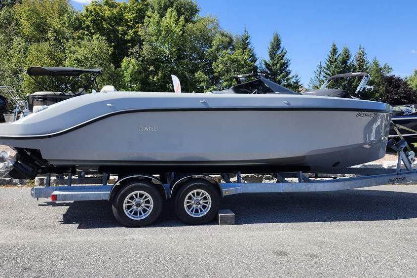 2022 Rand 25 SPIRIT boat on trailer, parked outdoors with trees in background.