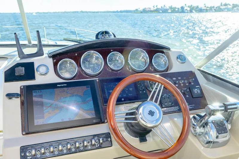 Sol Mates Yacht Photos Pics Cockpit of 2013 Sea Ray 370 Venture with navigation screens and wooden steering wheel.