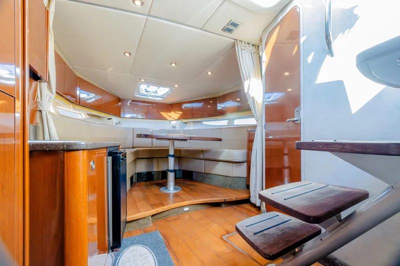 Sol Mates Yacht Photos Pics Interior of 2013 Sea Ray 370 Venture yacht, featuring elegant wood finishes and cozy seating area.