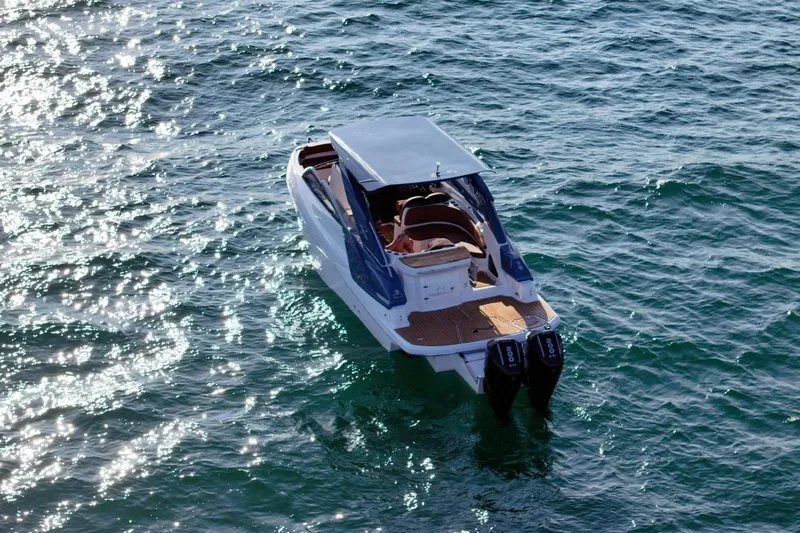  Yacht Photos Pics 2024 NX 280 Xtreme boat on shimmering water, rear view with dual engines.