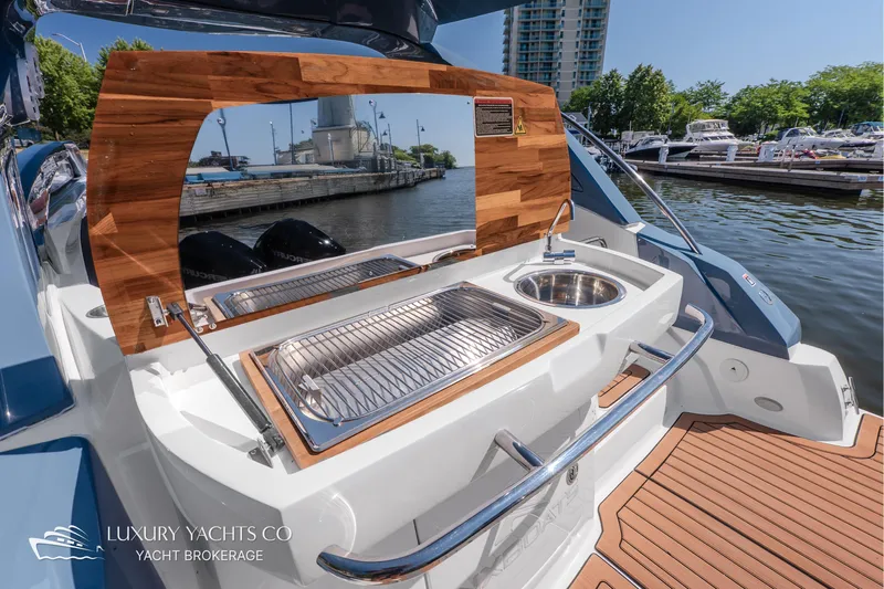  Yacht Photos Pics Outdoor kitchen on 2024 NX 280 Xtreme yacht with sink and grill, docked at marina.