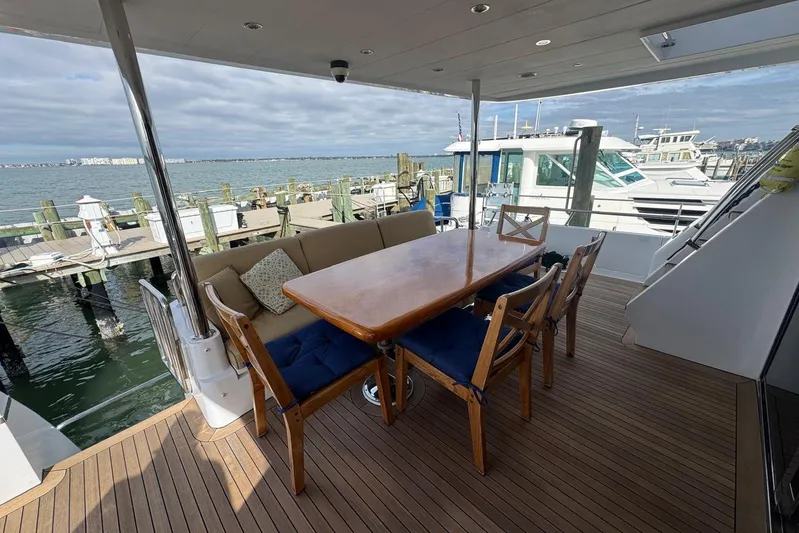  Yacht Photos Pics 2003 Hargrave Open Bridge yacht deck with dining table and marina view.