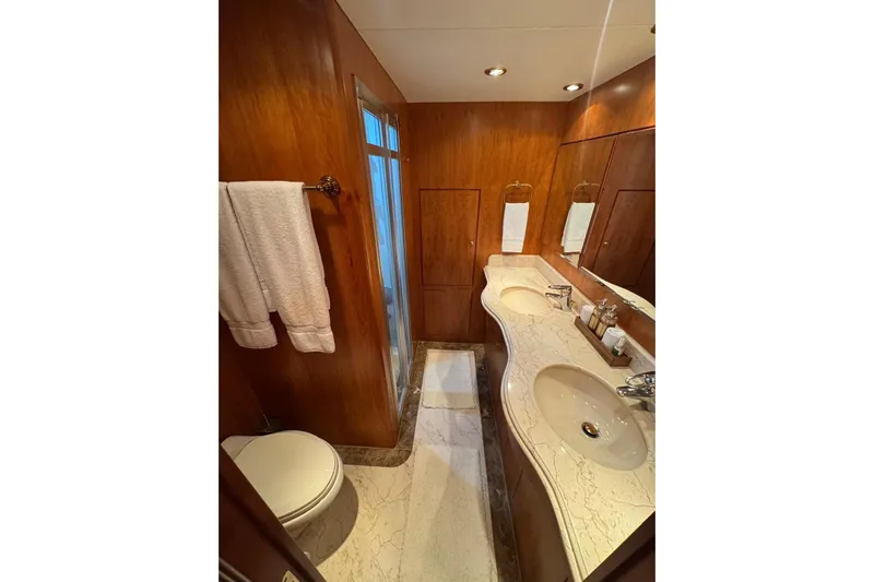 Yacht Photos Pics Luxurious yacht bathroom with marble countertops, wooden paneling, and elegant fixtures on a 2003 Hargrave Open Bridge.