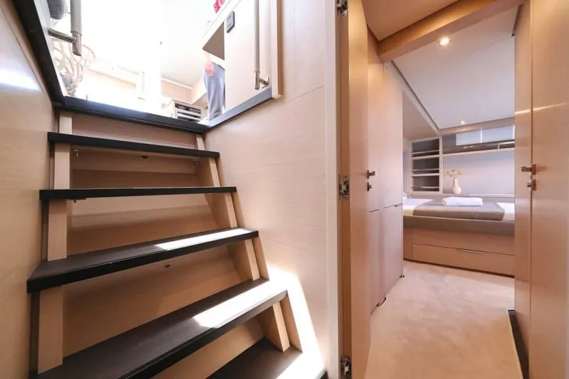  Yacht Photos Pics Interior of 2023 Lagoon 55 yacht, featuring stairs and a cozy bedroom.