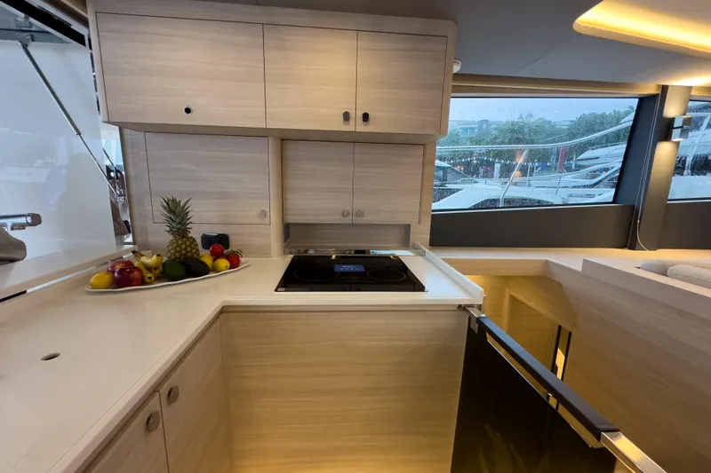  Yacht Photos Pics Modern kitchen interior of 2025 Aquila 50 Yacht with fruit display and sleek cabinetry.