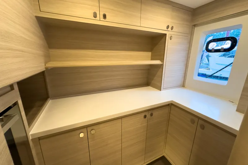  Yacht Photos Pics Modern kitchen interior of 2025 Aquila 50 Yacht with sleek cabinetry and window view.