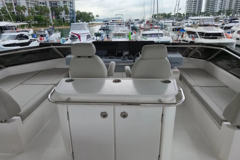  Yacht Photos Pics Luxury interior of 2025 Aquila 50 Yacht at marina, featuring helm and seating area.