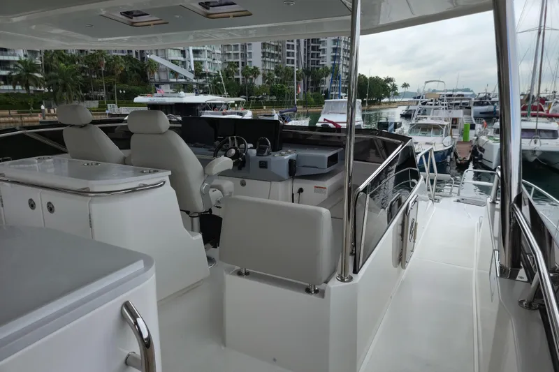  Yacht Photos Pics 2025 Aquila 50 Yacht interior with helm, docked in marina setting.
