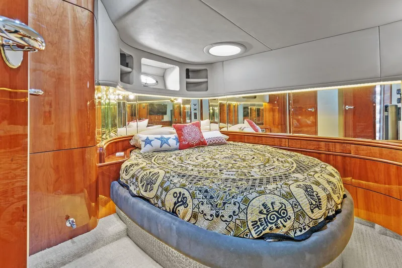  Yacht Photos Pics Luxurious bedroom interior of 2002 Sea Ray 550 Sundancer yacht with round bed and wood paneling.