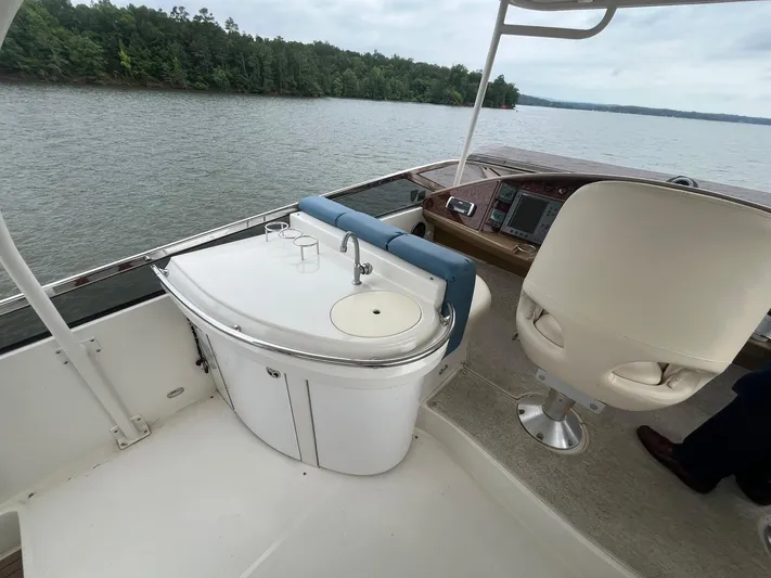 Juli's Priority Yacht Photos Pics 2004 Marquis 59 yacht interior with helm, sink, and seating by a lake.