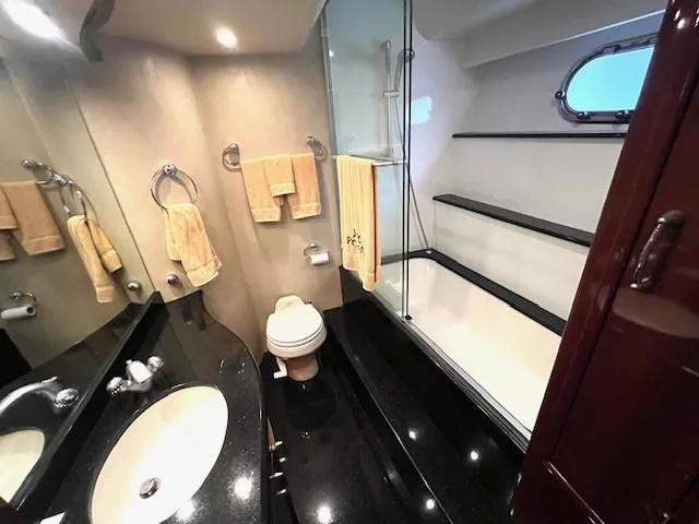 Juli's Priority Yacht Photos Pics Luxurious bathroom in 2004 Marquis 59 yacht with sleek black countertops and modern fixtures.