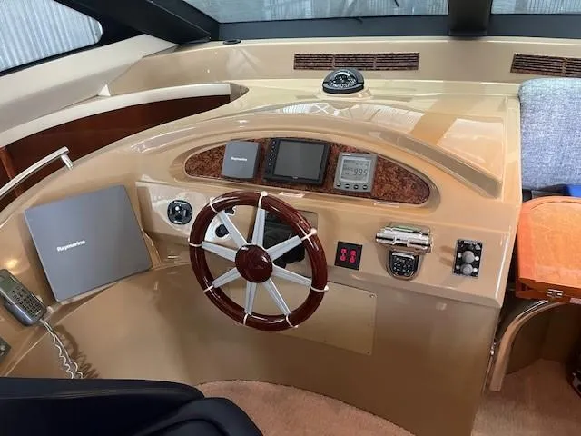 Juli's Priority Yacht Photos Pics 2004 Marquis 59 yacht helm with steering wheel, navigation instruments, and control panel.