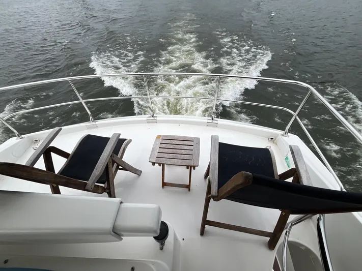 Juli's Priority Yacht Photos Pics 2004 Marquis 59 yacht deck with chairs and table overlooking water.