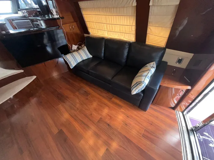 Juli's Priority Yacht Photos Pics Luxurious interior of a 2004 Marquis 59 yacht with leather sofa and wooden flooring.