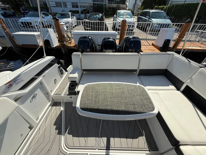  Yacht Photos Pics 2020 Monterey 385 Super Express boat interior with seating and table at a marina.