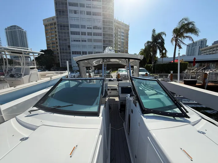  Yacht Photos Pics 2020 Monterey 385 Super Express boat docked near modern buildings and palm trees.