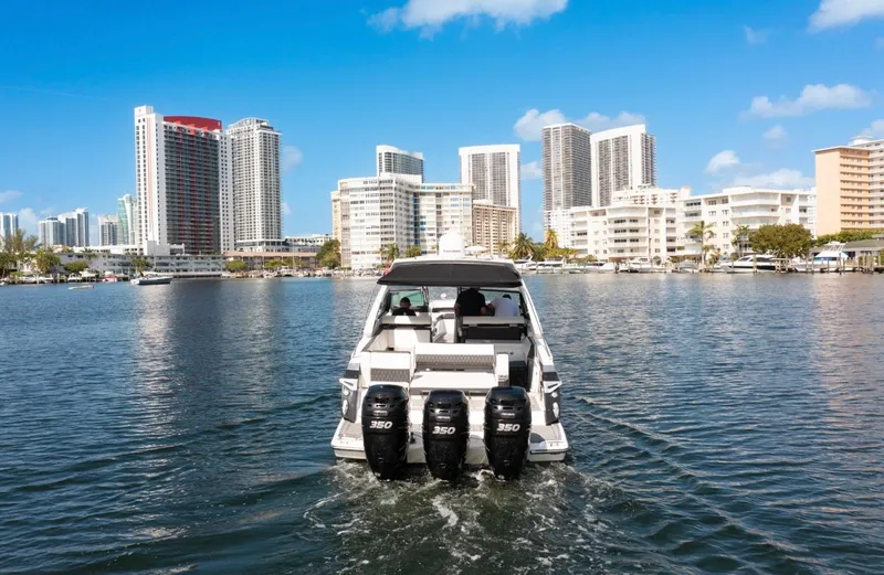  Yacht Photos Pics 2020 Monterey 385 Super Express boat cruising near city skyline.