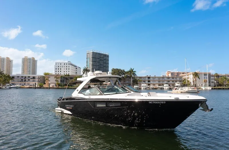  Yacht Photos Pics 2020 Monterey 385 Super Express boat cruising in a marina with cityscape background.