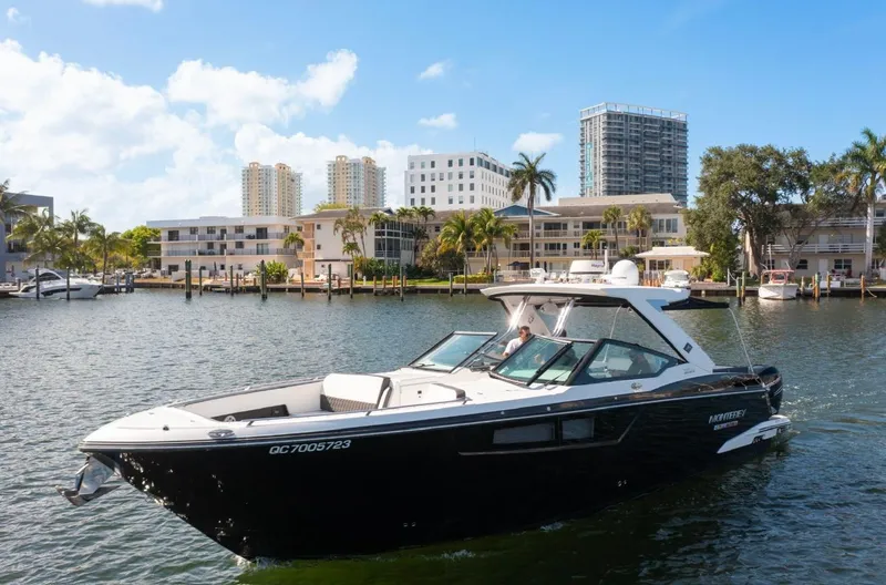  Yacht Photos Pics 2020 Monterey 385 Super Express boat cruising near waterfront buildings under a clear blue sky.