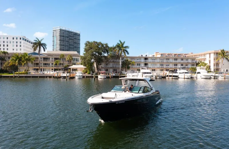  Yacht Photos Pics 2020 Monterey 385 Super Express cruising in a marina with palm trees and buildings in the background.