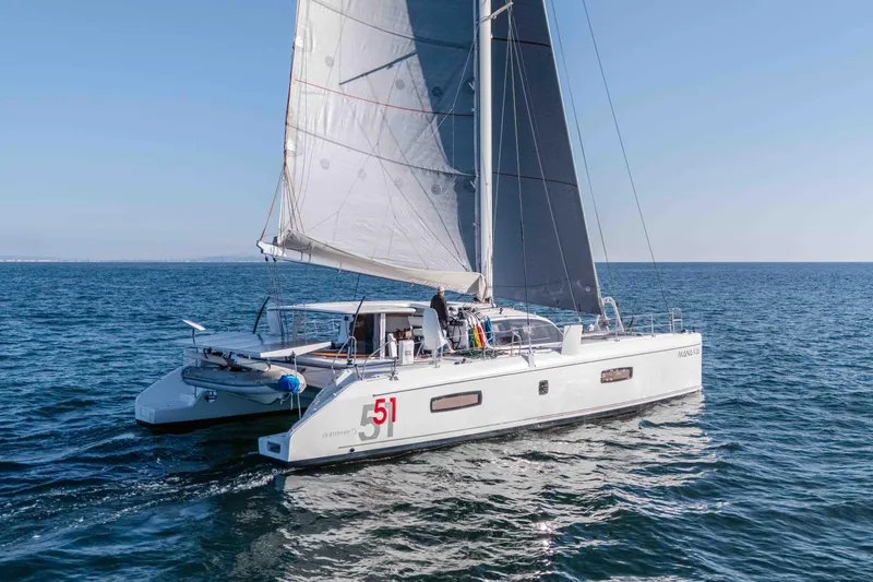  Yacht Photos Pics 2014 Outremer 51 catamaran sailing on open sea under clear blue sky.