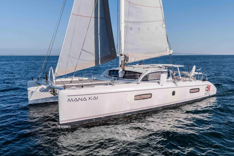  Yacht Photos Pics 2014 Outremer 51 catamaran sailing on open sea, named "Mana Kai".