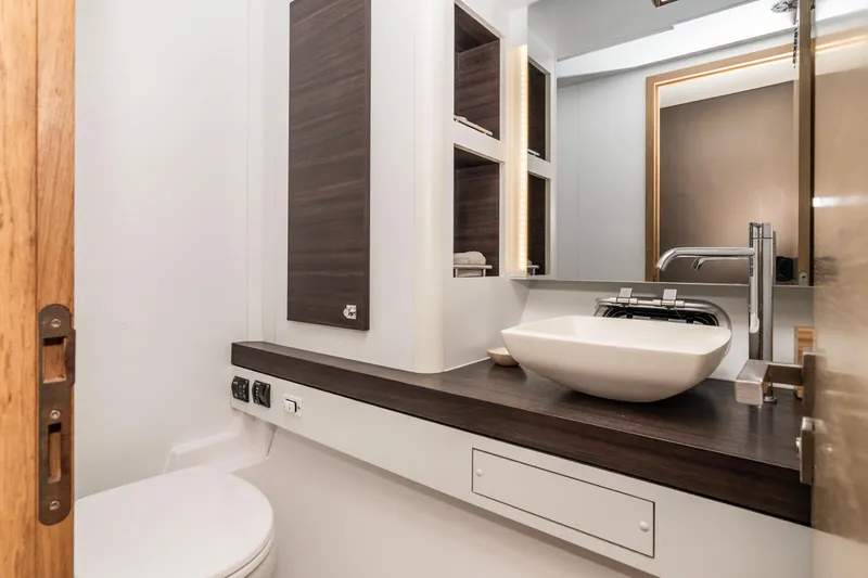  Yacht Photos Pics Modern bathroom interior on 2014 Outremer 51 yacht, featuring sleek sink and wooden accents.