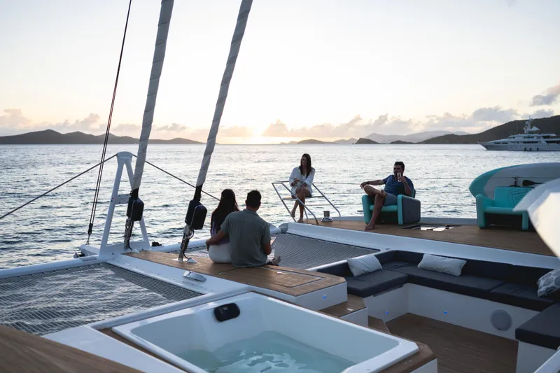My Ty Yacht Photos Pics People relaxing on a 2021 Fountaine Pajot Catamaran Alegria 67 at sunset.