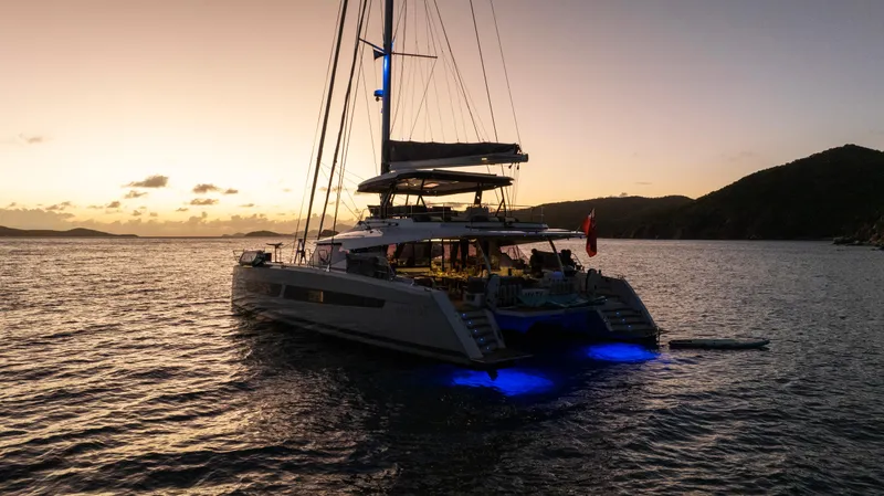 My Ty Yacht Photos Pics Fountaine Pajot Catamaran Alegria 67 at sunset, 2021 model, with blue underwater lights.