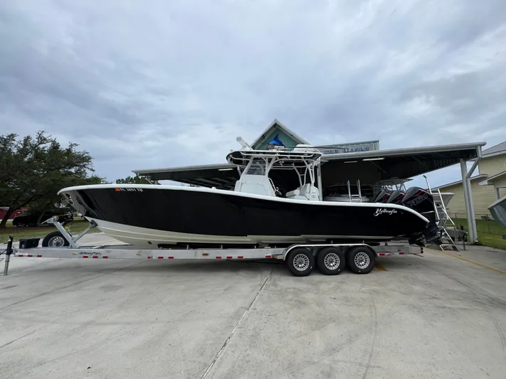  Yacht Photos Pics 2021 Yellowfin 36 Offshore boat on trailer, parked outdoors under cloudy sky.