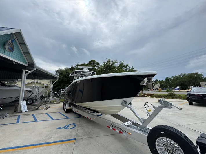  Yacht Photos Pics 2021 Yellowfin 36 Offshore boat on trailer at dealership, under cloudy sky.