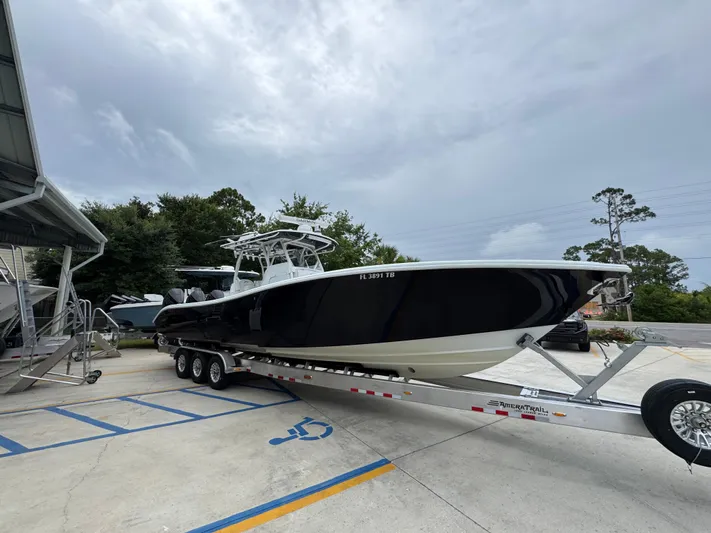  Yacht Photos Pics 2021 Yellowfin 36 Offshore boat on trailer, parked outdoors under cloudy sky.