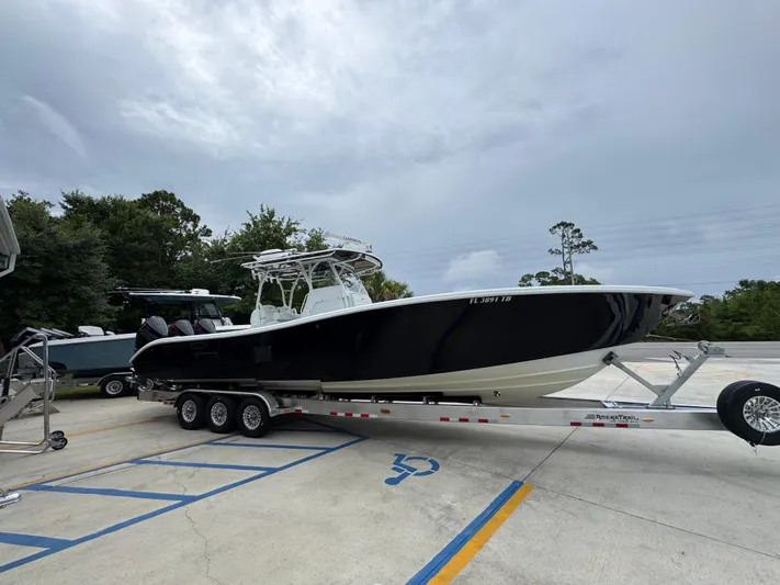  Yacht Photos Pics 2021 Yellowfin 36 Offshore boat on trailer, parked outdoors under cloudy sky.