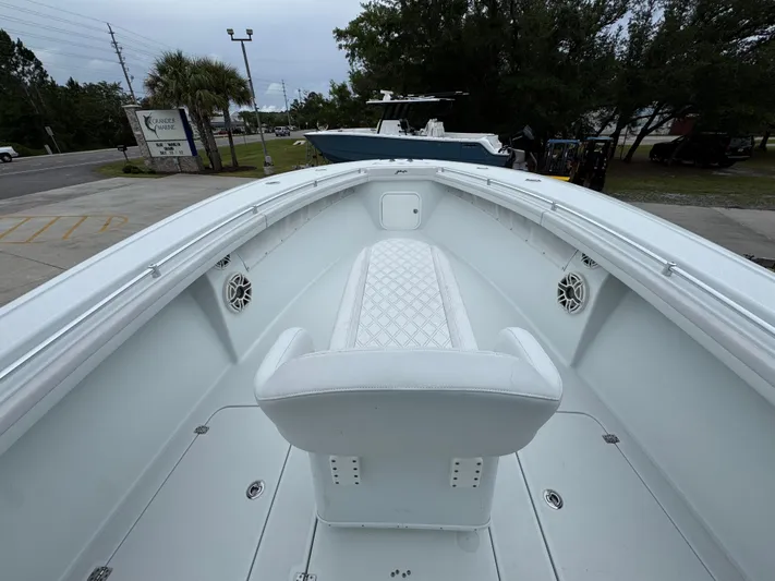  Yacht Photos Pics 2021 Yellowfin 36 Offshore boat interior with white seating and speakers, docked outdoors.