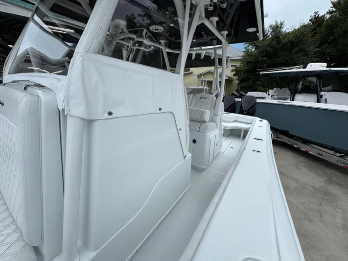  Yacht Photos Pics 2021 Yellowfin 36 Offshore boat interior with white seating and console, parked outdoors.