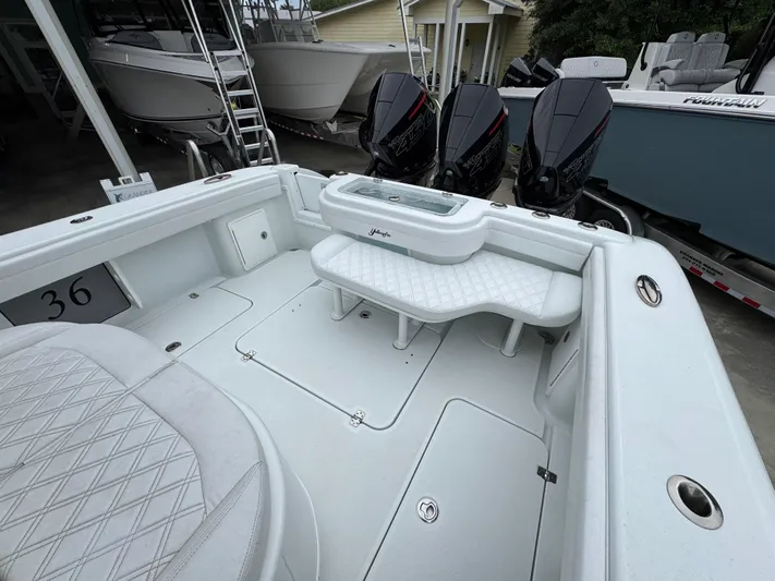  Yacht Photos Pics 2021 Yellowfin 36 Offshore boat interior with triple outboard engines, white seating, and storage compartments.