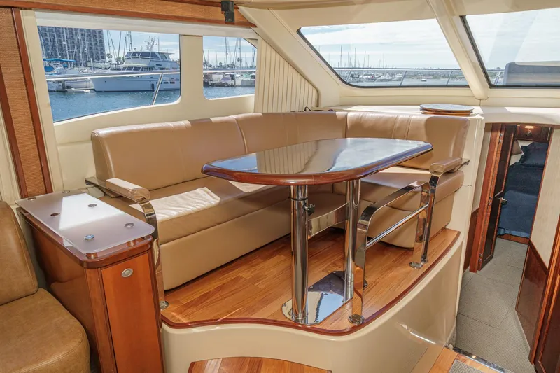  Yacht Photos Pics Luxurious interior of 2005 Sea Ray 500 Sedan Bridge yacht with leather seating and wooden table.