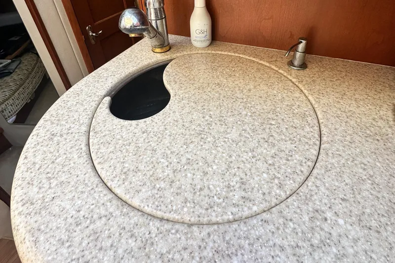 "fish N Chicks" Yacht Photos Pics 2005 Silverton 34 Convertible yacht kitchen sink with round cover and faucet.